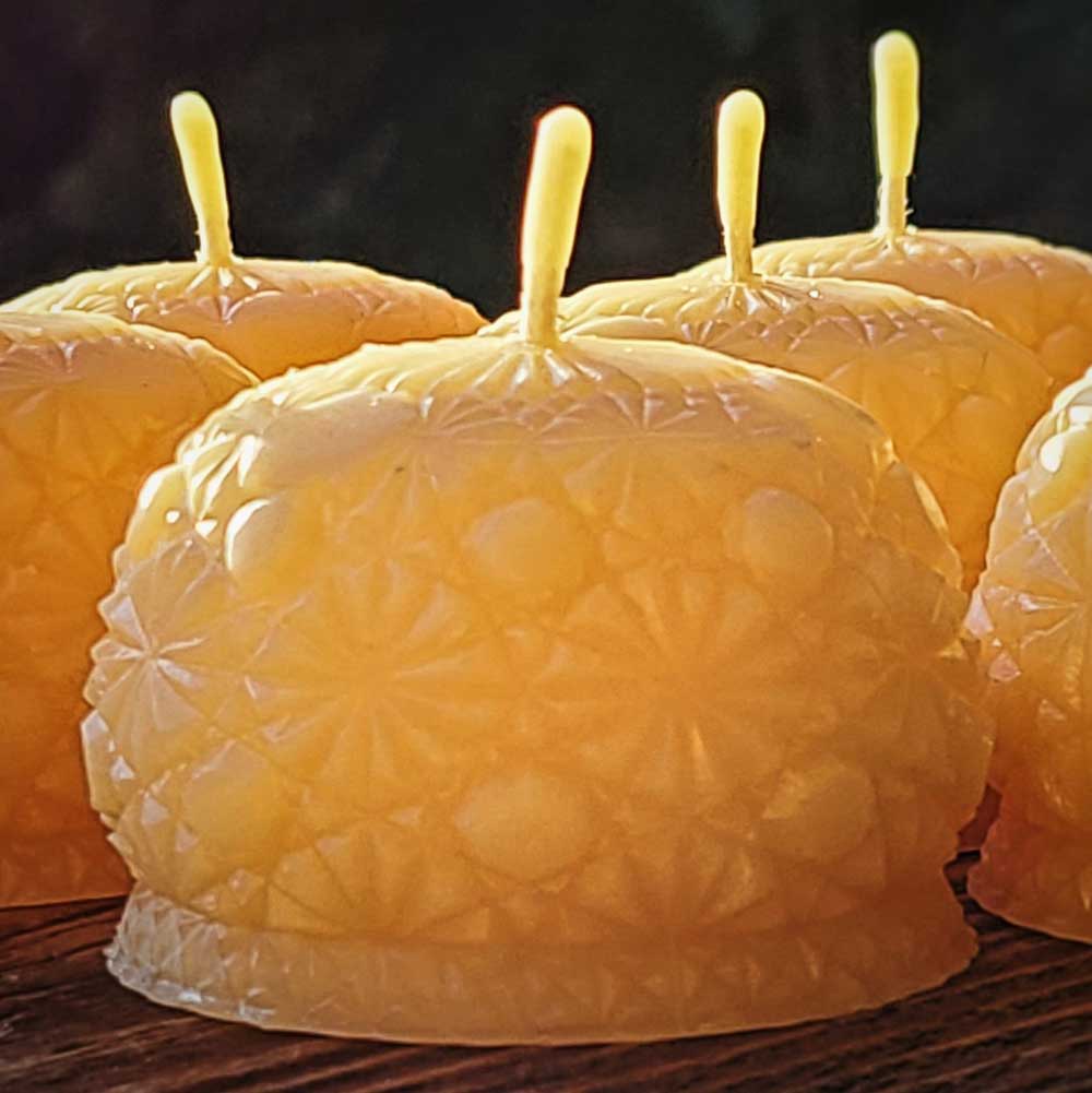 round beeswax candles with intricate design patterns