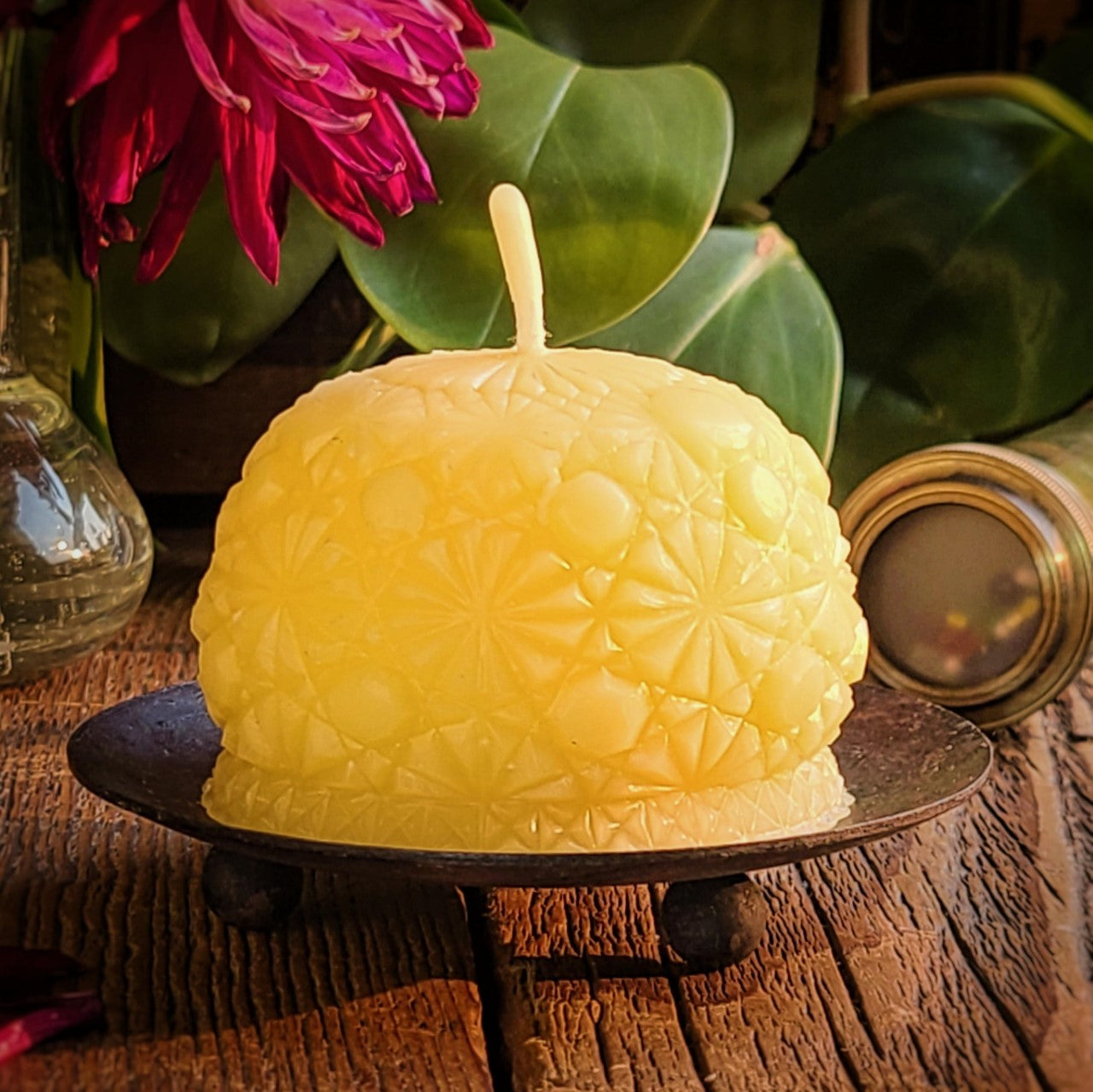 round beeswax candle with intricate pattern