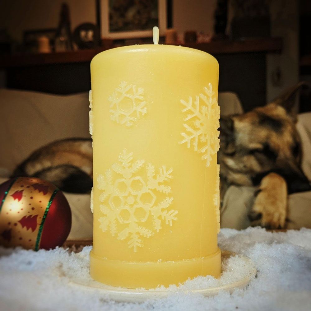 'First Snowfall' natural beeswax snowflake pillar candle, lit