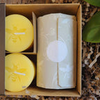 Yellow beeswax votive burning in a glass votive holder